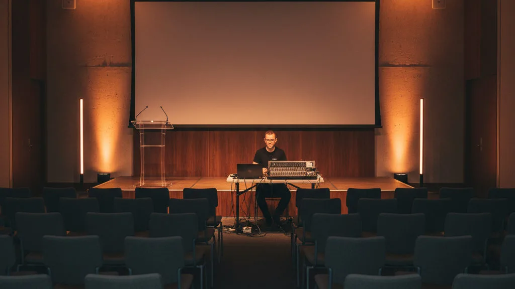 Seminariezaal met stoelenopstelling, podium en zaaltechniek klaar voor het programma